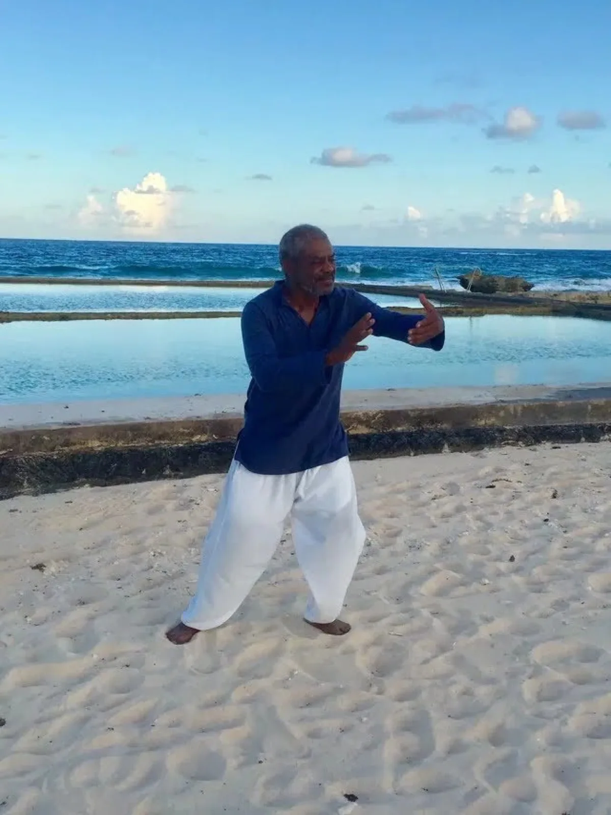 Dr. Larry Trott practicing Qigong at sunrise on the beach